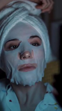 Pijamalı kız gece yatak odasında dizüstü bilgisayardan video izliyor. portre