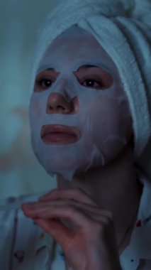 Pijamalı kız gece yatak odasında dizüstü bilgisayardan video izliyor. portre