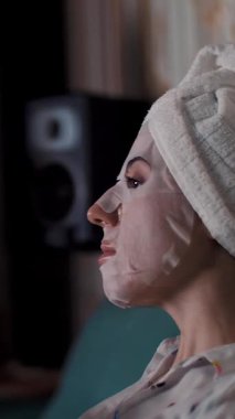 Pijamalı kız gece yatak odasında dizüstü bilgisayardan video izliyor. portre