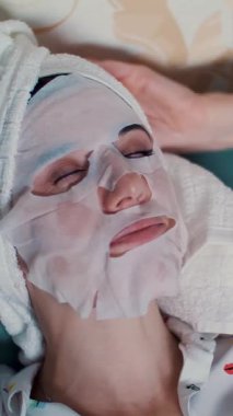 Pijamalı kız gece yatak odasında dizüstü bilgisayardan video izliyor. portre