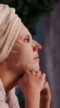 Pijamalı kız gece yatak odasında dizüstü bilgisayardan video izliyor. portre