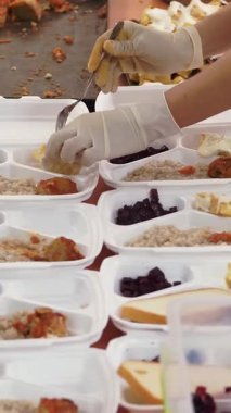 Yakın plan, Gönüllüler Covid19 hapsi sırasında fakirler için beslenme çantalarına bedava sıcak yemek koyuyorlar. Yemek servisi. Yardım projesi, bağış yardımı