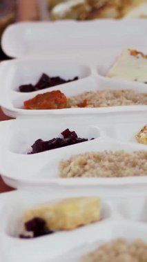 Yakın plan, tek kullanımlık eldivenler, yardım çantalarına sıcak yemek doldurur. Gönüllüler tarafından 19. koğuş boyunca fakir insanlara ücretsiz teslim edilir. Yemek servisi.