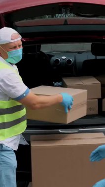 Coronavirüs salgını sırasında hastaneye tıbbi ekipmanla paket teslimatı. Kurye, koruyucu maskeli, eldivenli, doktorlara karton kutular veriyor, tıp uzmanı. Kargo teslimat servisi karantina sırasında.