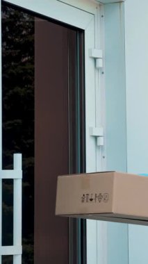 Coronavirüs salgını sırasında hastaneye tıbbi ekipmanla birlikte paket teslimatı. Kurye, koruyucu maskeli, eldivenli, doktora karton kutu veriyor, tıp uzmanı. Kargo teslimat servisi karantina sırasında.