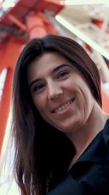 Dönme dolabın arka planında gülümseyen güzel esmer kadın..