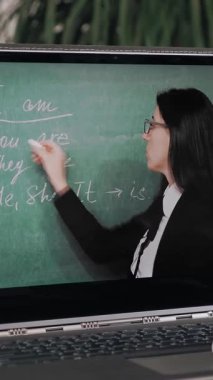 Uzaktan öğrenme, online eğitim. Laptop ekranına yakın çekim. Liseli kız, öğretmeninin açıklamalarıyla online video dersi izliyor ve not defterine not alıyor. Evde online ders çalışıyorum..