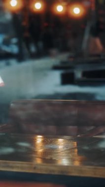 Yakın plan. Garson, koruyucu maske ve eldiven takmış, antiseptik sprey ve temizlik peçetesi kullanarak restoran masasını temizliyor. Pencereden bak. pandemik koronavirüs.