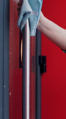 Bir restoranda ya da kafede temizlik. Yakın plan. Garsonluk, restoran girişinin kapısını silme, antiseptik sprey kullanma ve peçete temizleme..