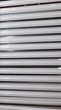 Perde kornişleri. Yakın plan. Yeni boyanmış alüminyum beyaz kornişler, kurutma odasından sonra boya atölyesindeki kornişler. Perde kordonlarının imalatı. Yapım atölyesinde resim.