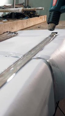 CHERKASSY, UKRAINE, FABRUARY 10, 2021: kat kaplamalarının birleşimi. Yakın plan. iş akışı, dekoratif şeritler ve alüminyum bantlar paketleme süreci, zemin kaplamalarını bağlamak için eklemler