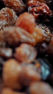 Kuru üzüm. Yakın plan. Rotasyon yemeği. Üzüm arka planı yavaş döner, üst görünüm. Sağlıklı beslenme için kuru meyve, hafif ve koyu kuru üzüm. Yemek geçmişi. Gastronomi konsepti, organik gıda..