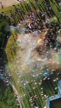 Pudra boyaları. Havacılık. Üst hava manzaralı. Birçok insan parkta renk festivali sırasında kuru boya tozu atarak eğleniyor. yaz