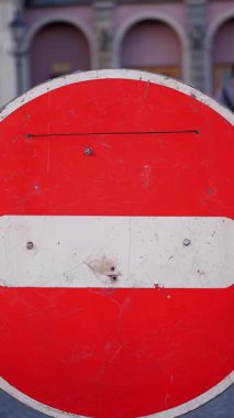 Dur, giriş yok. Dur işareti. Kırmızı tuğla. Yol tabelası. İmza atmayın. Yakın plan. Yürüme alanının önünde trafik işareti yok. birçok bulanık insan siluetinin arka planına karşı.