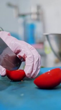 Yemek pişirmek. Şef sebze keser. Açık büfe restoran mutfağı. Yakın plan. Şef taze domatesi küçük parçalara ayırıyor. Plastik tahta üzerinde keskin, büyük bir mutfak bıçağıyla..