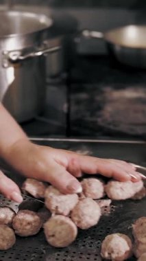 Yarı bitmiş et ürünleri. Yemek pişirmek. Yakın plan. Şef, yarı bitmiş et ürünlerini, donmuş köfteleri kaynar suya koyar. Ticari bir mutfakta yemek pişirmek..