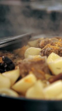 Yemek pişirmek. Güveç. Açık büfe restoran mutfağı. Yakın plan. Yemek kaynıyor, tencerede kaynıyor. Ticari bir mutfakta yemek hazırlamak ve pişirmek.