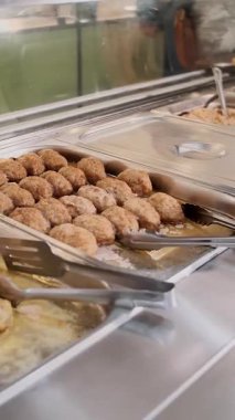 Açık büfe restoranı. Kendi kendine hizmet veren kafeterya. Yakın plan. Yeni pişmiş sıcak yemeklerle sergilenen bir vitrin. sağlıklı gıda.