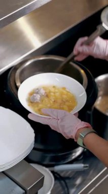 Açık büfe restoranı. Kendi kendine hizmet veren kafeterya. Yakın plan. Garson, koruyucu eldivenlerle müşteriye sıcak çorba dolduruyor. Yemek pişirmek. sağlıklı gıda.
