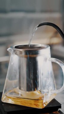 Çay içeceğim. Çay yapıyorum. Yakın plan. Çay ustası cam çaydanlığa armut dilimleriyle kaynar su döker. özel sıcak meyve çayı pişirme süreci.