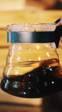 Damlayan kahve demleniyor. Kahve demliği. Yakın plan. Kahveci elinde bir çaydanlık ile kahve tutuyor, karıştırıyor.