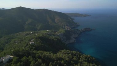 2022 yazında İbiza Dağı 'nın yamaç kenarındaki İbiza insansız hava aracını geri çekin. 4k Sinematik
