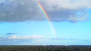 descending drone rainbow in blue sky, big cloud in brandenburg Germany at summer 2022. High Quality 4k Cinematic footage