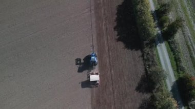 tracking shot from above drone tractor on fall field brandenburg havelland Germany at autumn 2022. High Quality 4k Cinematic footage