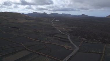 rotation to right drone black volcano ash track, lava field Spain, cloudy day 2023. High Quality 4k Cinematic footage.