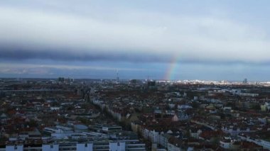 Berlin üzerinde gökkuşağı, Almanya 'da yağmurlu gri bulutlu gökyüzü bölgesi mitte. 4k ters uçakla uçun. Sinematik görüntüler..