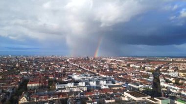 Berlin üzerinde gökkuşağı, Almanya 'da yağmurlu gri bulutlu gökyüzü bölgesi mitte. boom sağa kayıyor 4k uhd sinematik görüntüler.