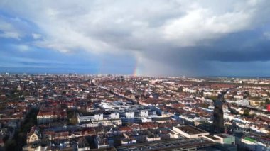 Berlin üzerinde gökkuşağı, Almanya 'da yağmurlu gri bulutlu gökyüzü bölgesi mitte. boom sağa kayıyor 4k uhd sinematik görüntüler.