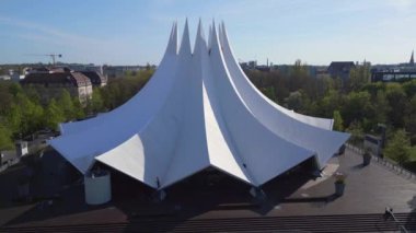 Berlin Tempodrom beyaz tentroof beton bina, Şehir Bölgesi Kreuzberg, Almanya baharı 2023 İHA 4k ters uçuşu -- sinematik görüntü.