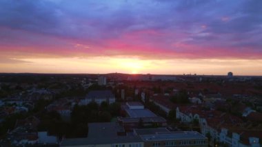 Pembe turuncu güneş şehri, Berlin Steglitz şehir merkezi üzerinde bulutlu bir gün batımı, Almanya 'nın başkenti, 2023 yaz akşamı panorama 4K hava aracı..