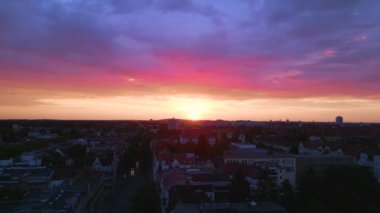 Pembe turuncu güneş şehri, Berlin Steglitz şehir merkezi üzerinde bulutlu bir gün batımı, Almanya 'nın başkenti, 2023 yaz akşamı panorama 4K hava aracı..