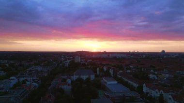Pembe turuncu güneş şehri bulutlu gün batımı Berlin şehir merkezi Steglitz, Almanya 'nın başkenti, 2023 yaz akşamı İHA 4K' dan iniyor..
