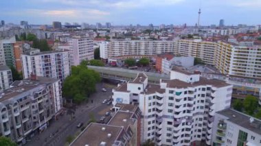 Berlin şehir banliyösü tren istasyonu Prefabrik gökdelenler bölgesi Neukoeln, Almanya Yaz günü 2023 Panorama yörünge dronu 4K Cinematic