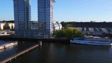 Sınır nehri kıyısındaki ikiz kule Spree, Doğu Berlin yaz akşamı 23 statik tripod 4k insansız hava aracı havada süzülüyor.