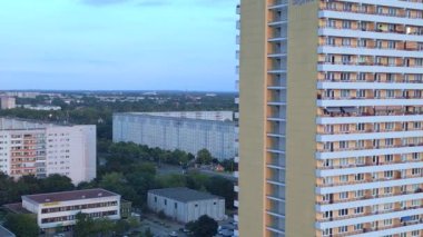 Berlin şehir konutları Marzahn Almanya. Panel sistem binası, prefabrik konut kompleksi, Marzahn Doğu Almanya altın saati 2023 sağ İHA 4K sinemasına kayıyor.