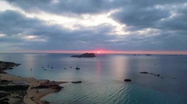 Bulutlu gün batımı plajı İbiza İspanya Kontu Ekim 2023 İHA yüksek kaliteli 4K görüntü.