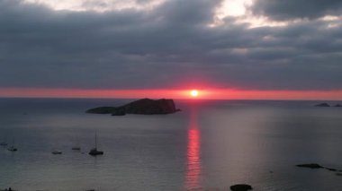 Bulutlu gün batımı plajı İbiza İspanya Kontu 2023 Ekim 'inde sol İHA Yüksek kaliteli 4K görüntüye kayıyor.
