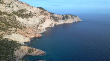 İbiza adası tepesinde uçurum yürüyüşü İspanya 'nın batışı. panorama yörünge drone 4k peyzaj görüntüsü