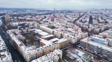 Kar yağışlı kış Berlin 'in karlı çatıları bulutlu gökyüzü. İHA 'dan alçalıyoruz. Yüksek kalite 4K görüntü