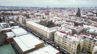 Kar yağışlı kış Berlin 'in karlı çatıları bulutlu gökyüzü. İHA 'yı ters uçur Yüksek kalite 4K görüntü