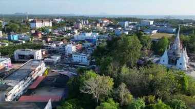 Arka planda tropikal manzarası olan sakin bir Tayland tapınağı üzerinde sol drone çekimine dönüş