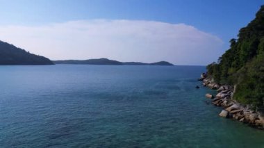 Serin, kumlu bir sahilin, yemyeşil bir ormanın ve berrak mavi suların ters uçuşu.