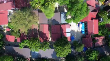 Tropik sahil manzarası kristal berrak su. Yukarıdan insansız hava aracı görüntüleri. Sakin bir tropikal plajın yukarıdan aşağı görüntüsü. Tekneleri ve canlı mercan resifleri var.