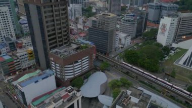 Kuala Lumpur Malezya şehir manzarası tren ve gökdelenlerle. Panorama insansız hava aracı. Yüksek binaların arasında trenin olduğu hareketli bir şehir manzarası