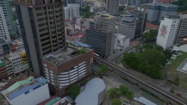 Kuala Lumpur Malezya şehir manzarası tren ve gökdelenlerle. Üstten kumandalı hava aracı. Yüksek binaların arasında trenin olduğu hareketli bir şehir manzarası
