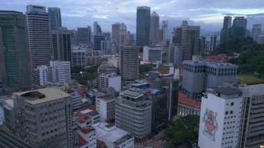 Kuala Lumpur Malezya şehir manzarası tren ve gökdelenlerle. İHA iniyor. Yüksek binaların arasında trenin olduğu hareketli bir şehir manzarası